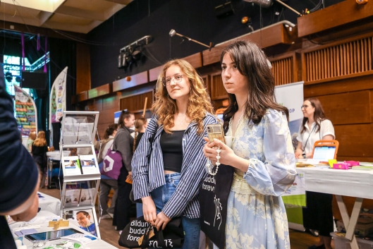 Zwei Teilnehmerinnen stehen vor einem Stand auf einer futureLink-Veranstaltung